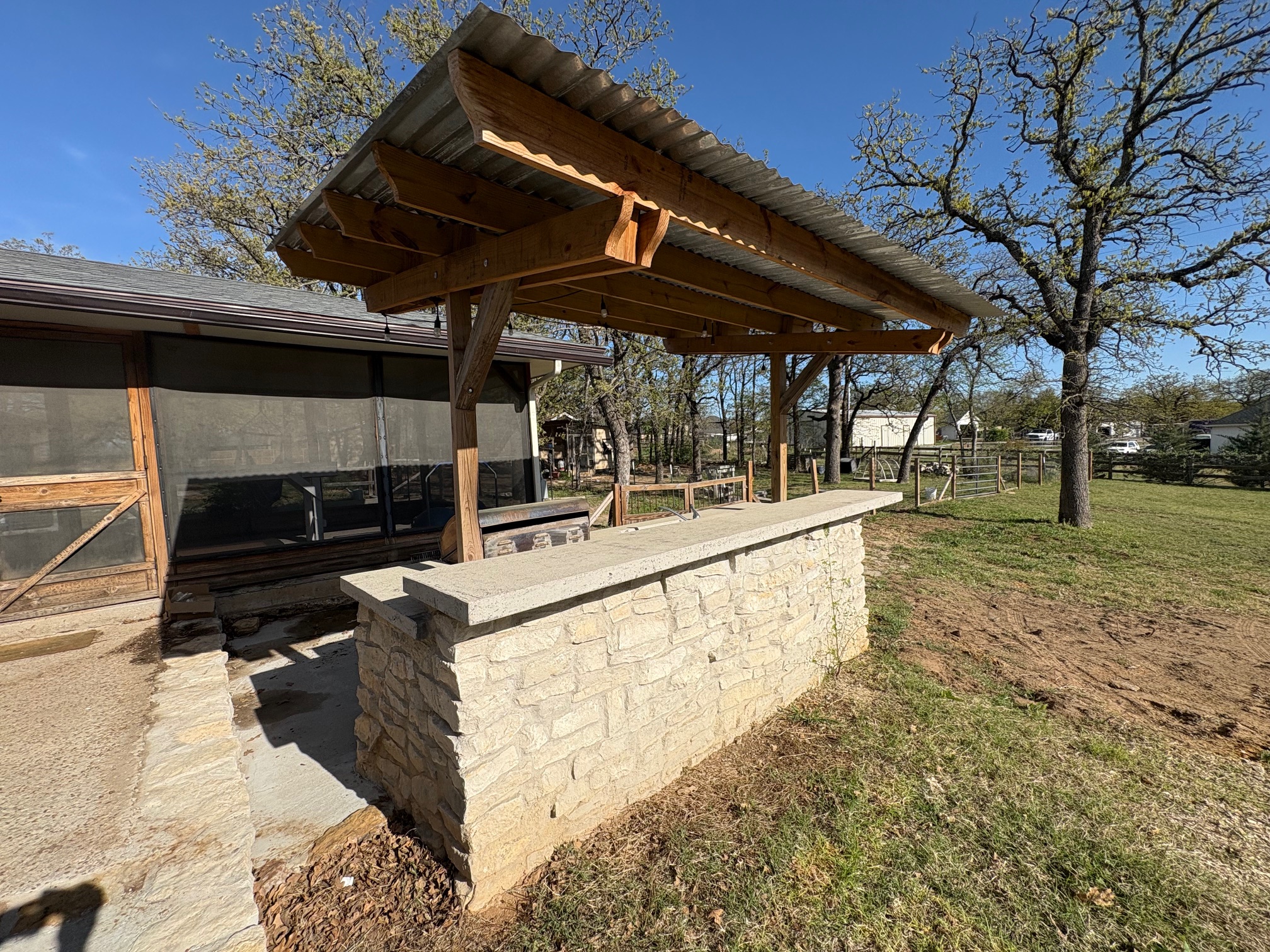 Covered patio bar with stone base and pergola